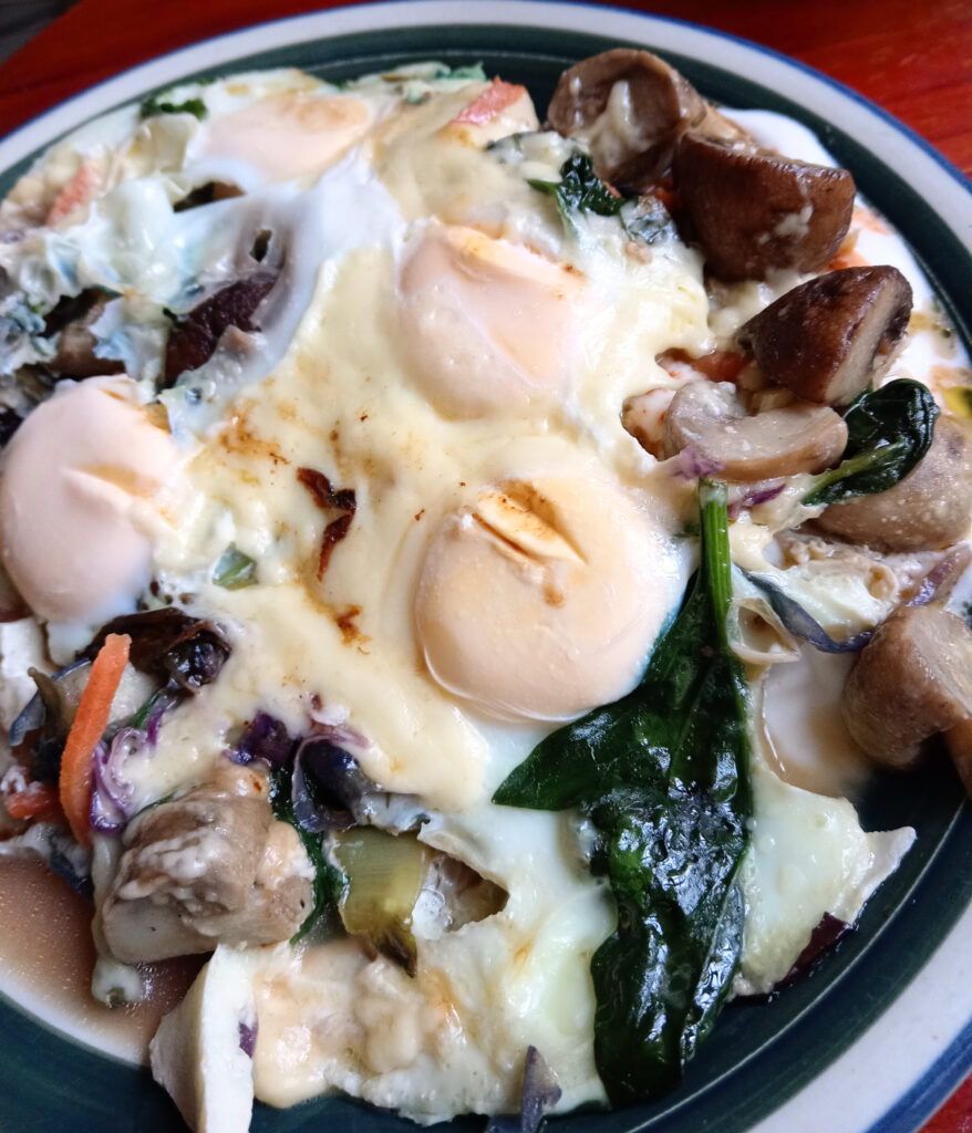 Breakfast of eggs, vegetables, melted mozzarella, yogurt and kimchi