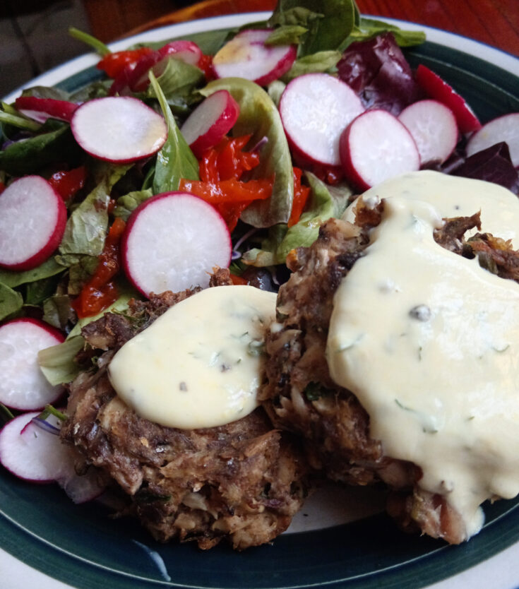 Golden mackerel fish cakes served with a dill and mustard yogurt dressing, Asian salad leaves, shredded peppadews, and sliced radishes.