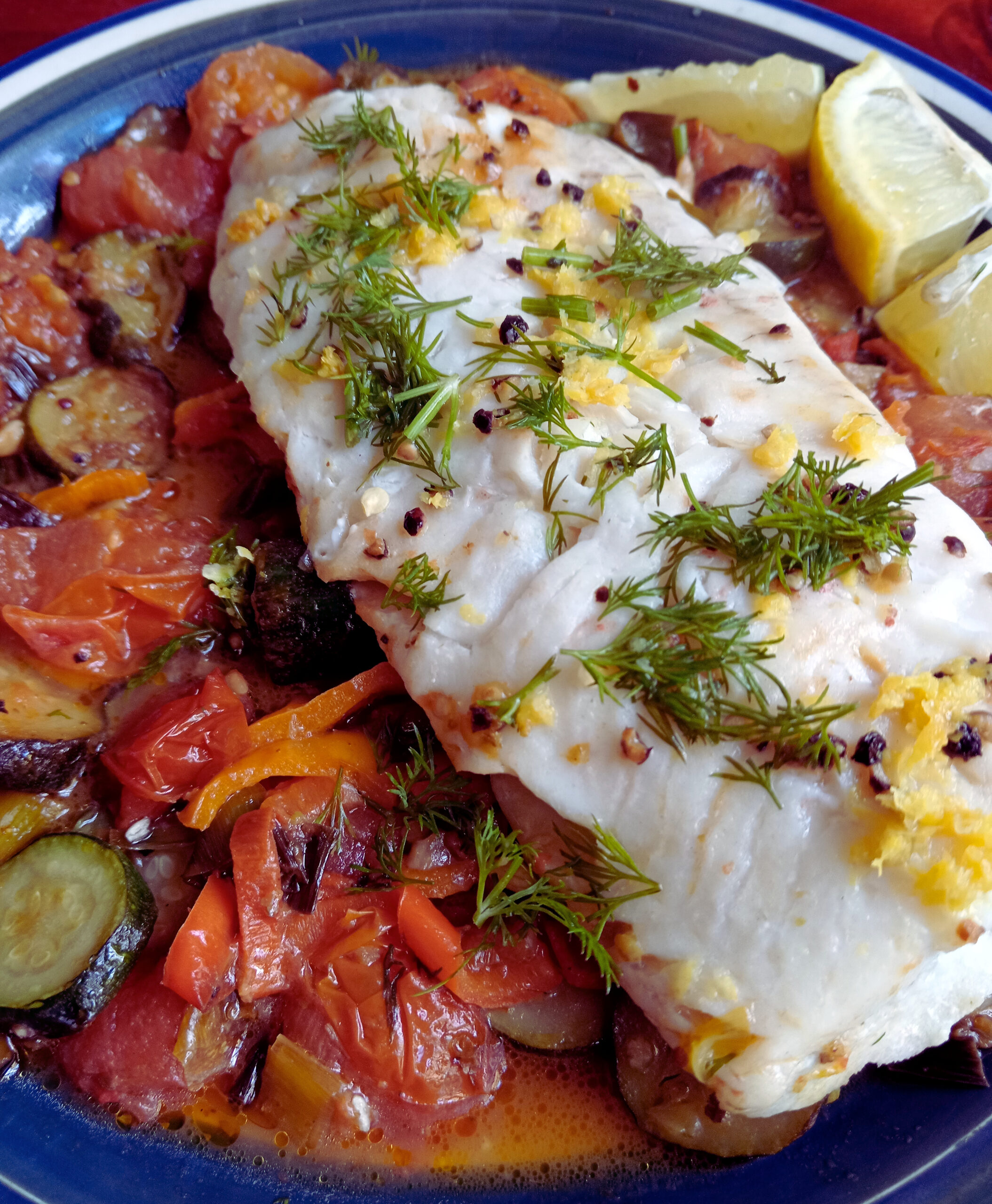 Mediterranean hake with tomatoes, baby leeks, zucchini, sweet peppers, lemon and fresh dill