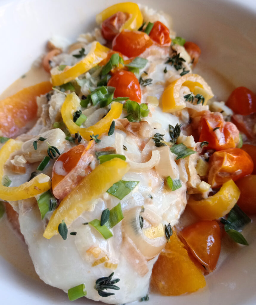 Caribbean-inspired hake rundown with fresh South African hake poached in a creamy coconut sauce, topped with cherry tomatoes, shallots, fresh thyme, spring onions and sweet baby peppers, served with steamed pumpkin.